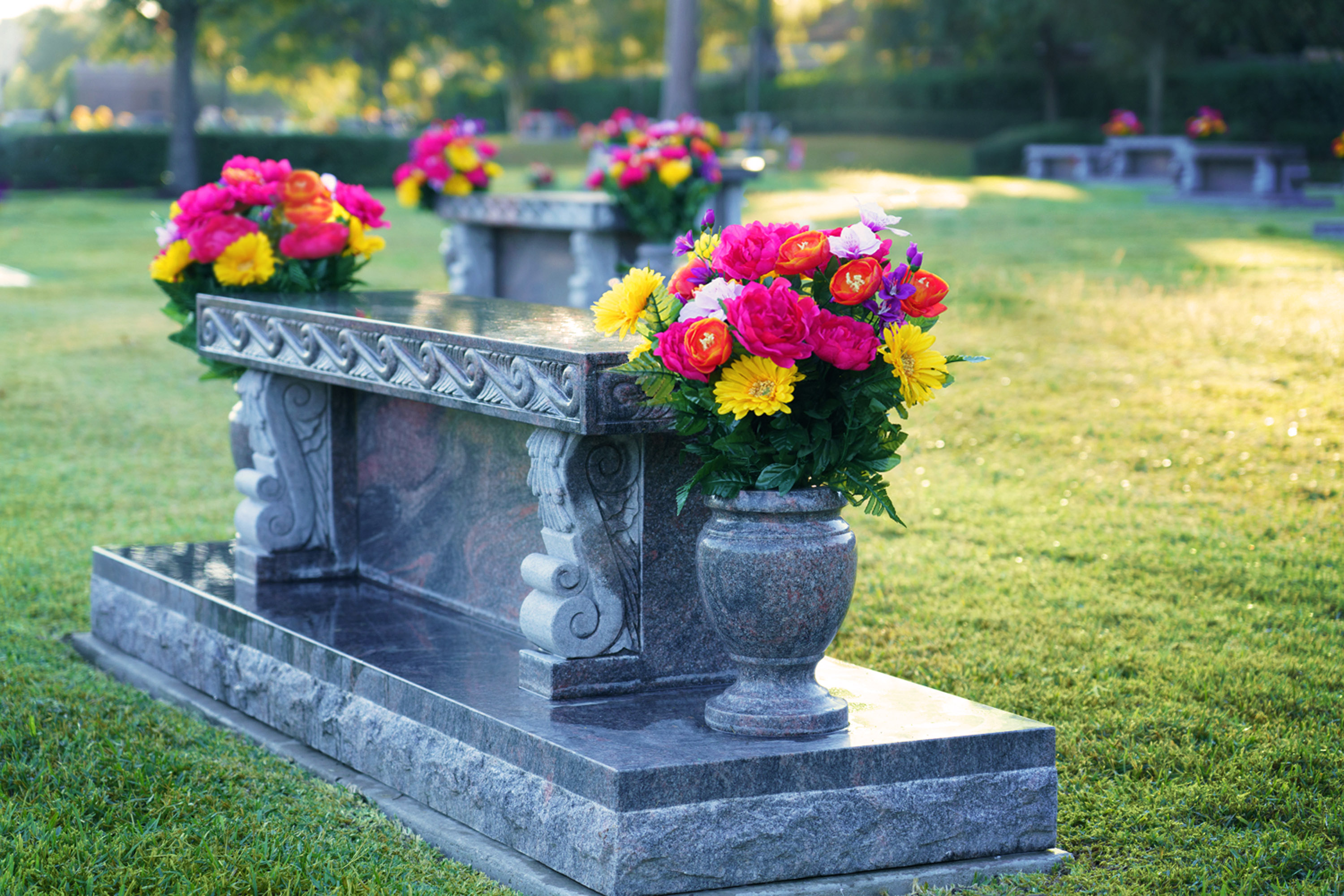 Beautiful floral arrangements on a memorial bench